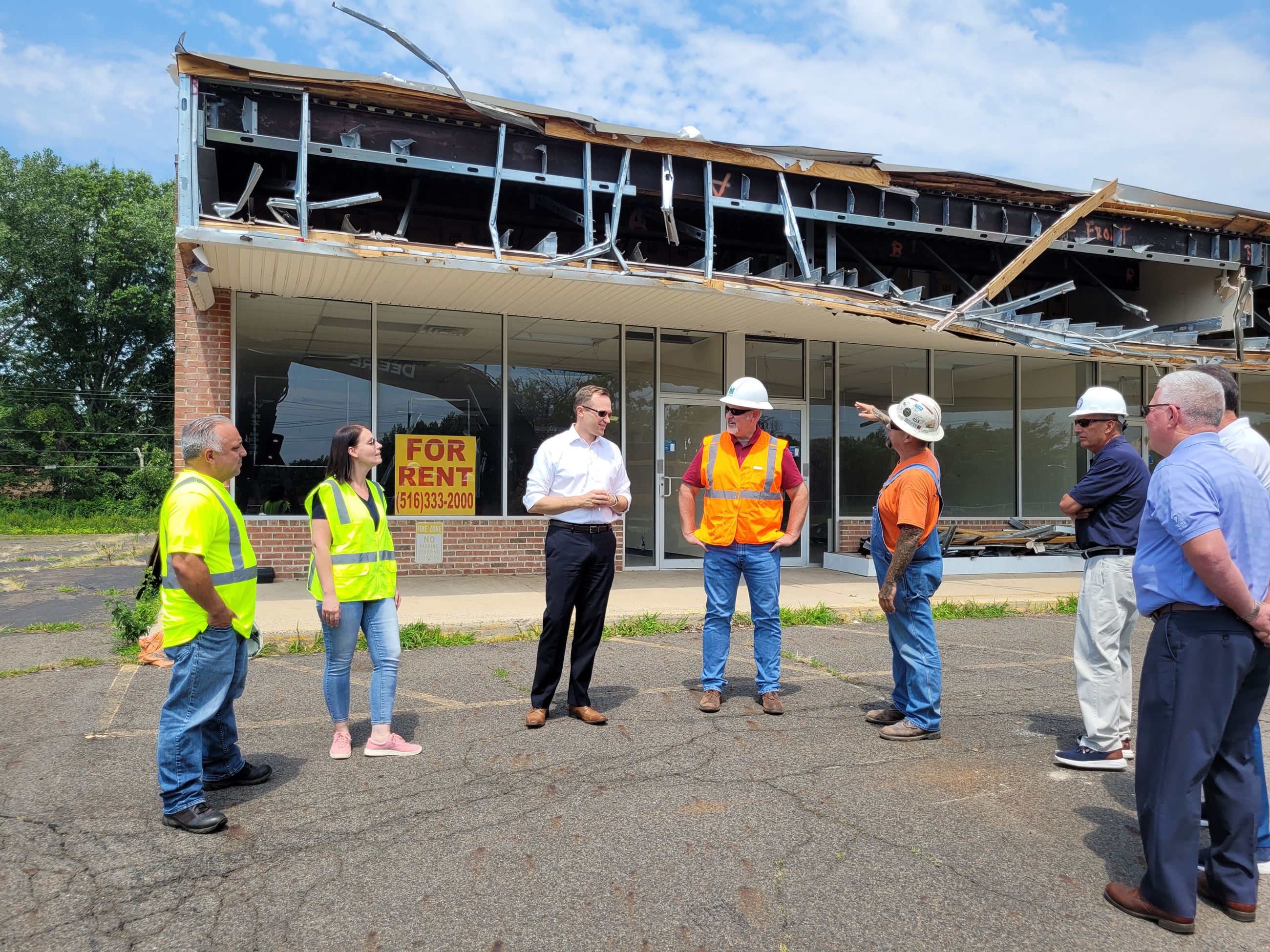 Officials standing in front of building to be demolished