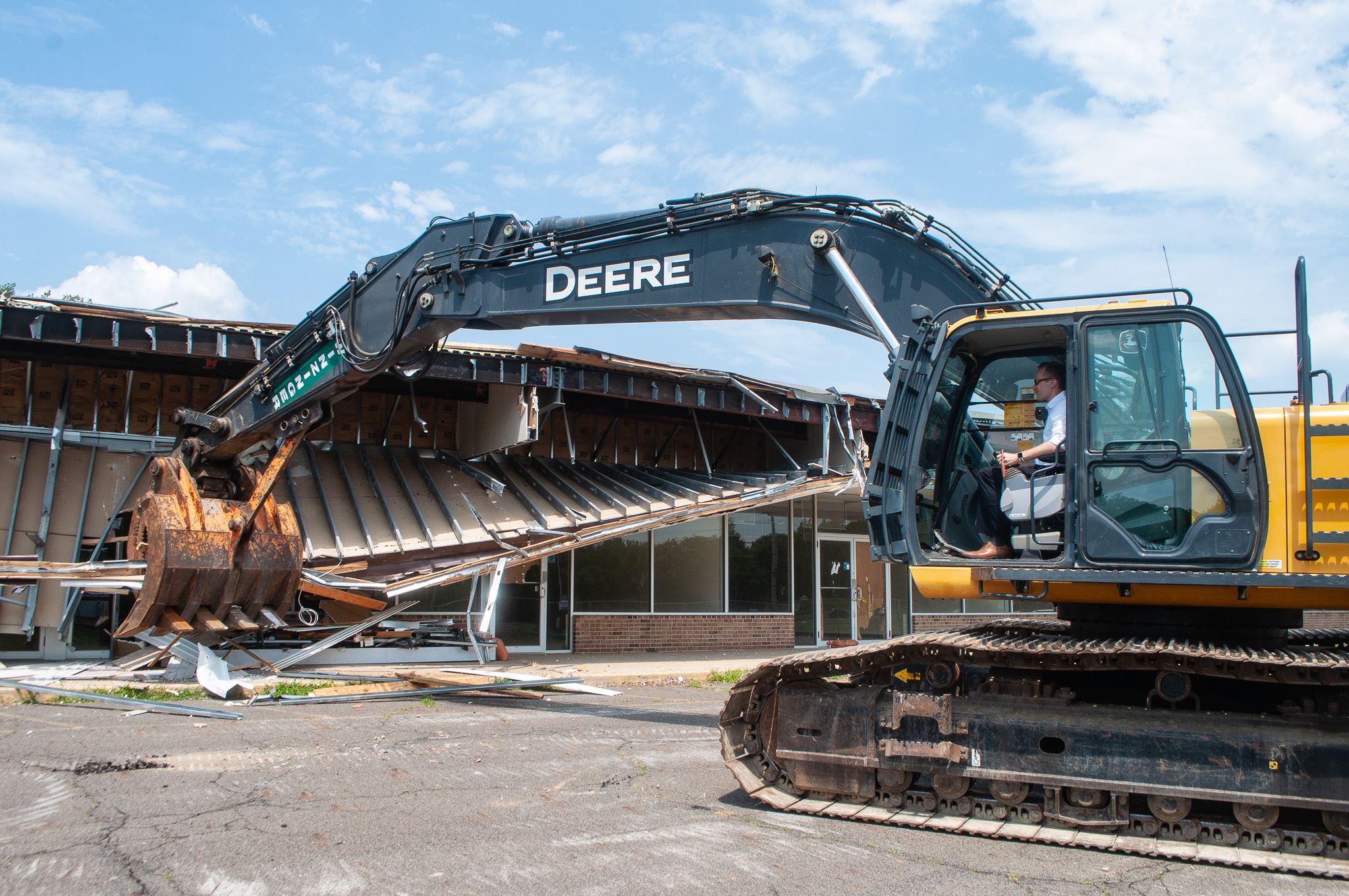 Mayor Martin in construction equipment tearing down building