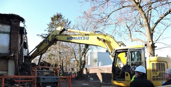 Backhoe demolishing fire damaged home on East State Street