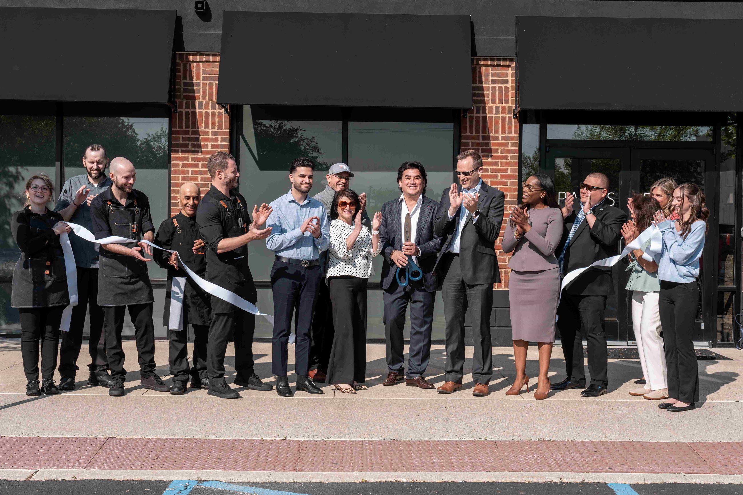 Group of people posing outside of Raza's for grand opening 
