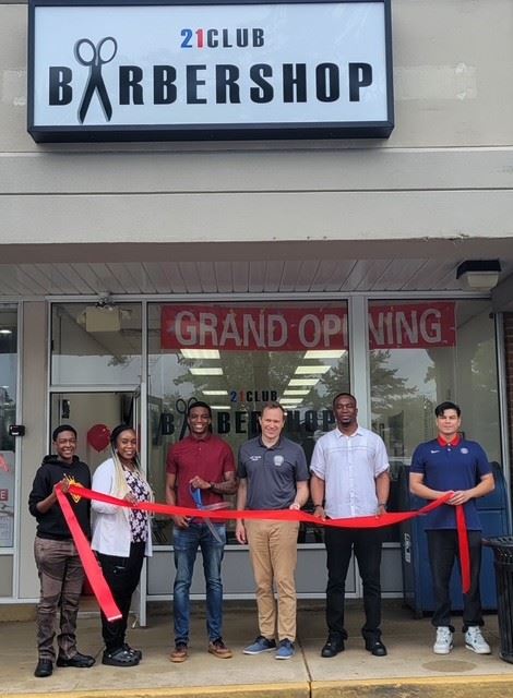 Image of owners and Mayor Martin celebrating the grand opening of 21 club barbershop